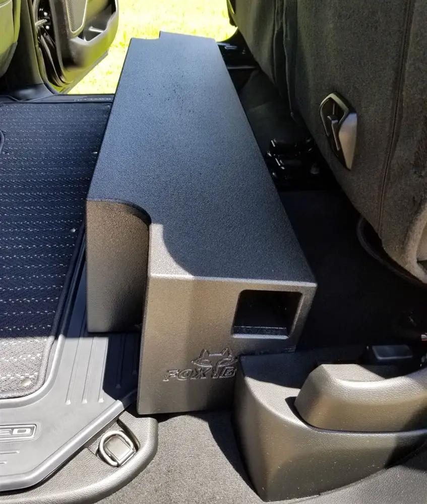 Fox Box Ram enclosure fitted under a raised rear seat, showing the side port beside the door sill
