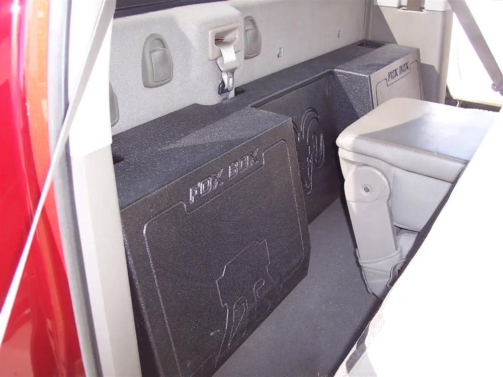 Black Fox Box enclosure positioned behind a seat, with its embossed logo and central recessed section visible