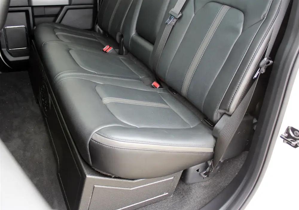 Truck rear bench seat lowered over a black under-seat subwoofer enclosure