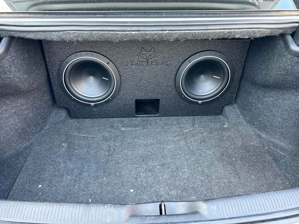 Fox Box enclosure with two installed subwoofers and a center port positioned in a carpeted trunk