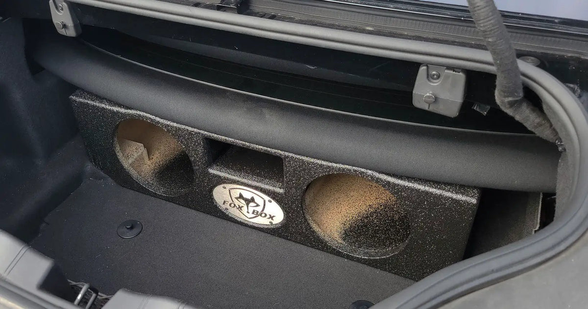 Fox Box enclosure with two empty speaker openings fitted beneath the rear deck in a trunk