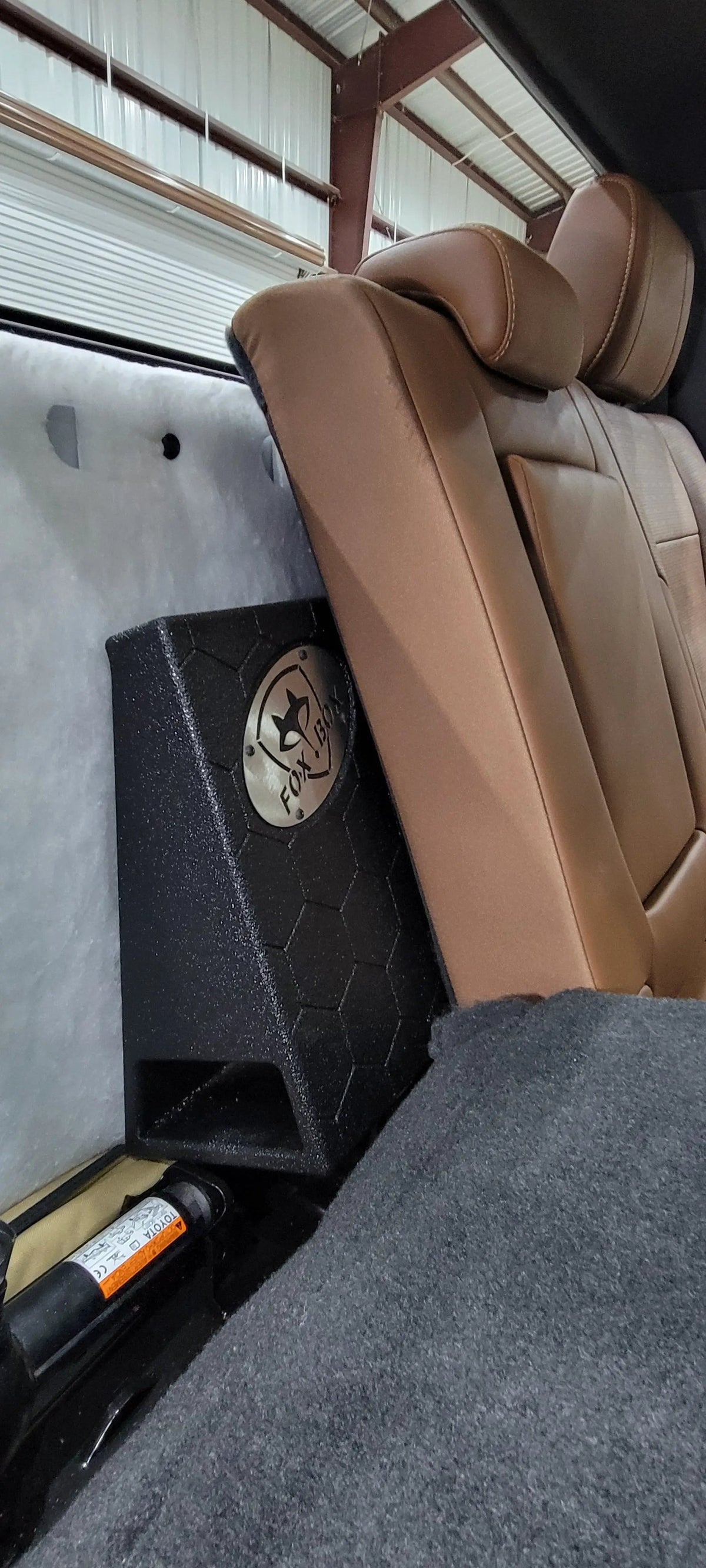Side view of a Fox Box enclosure positioned behind the rear seat back