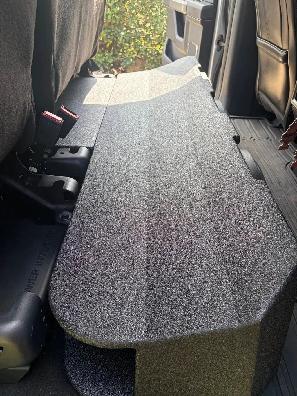 Black subwoofer enclosure fitted beneath the raised rear seat cushions