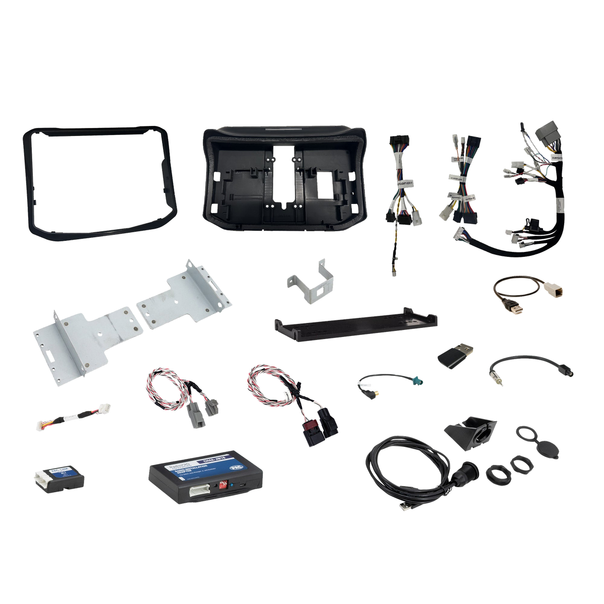 Radio installation components laid out with dashboard panels, mounting brackets, interface modules, wiring harnesses and adapter leads