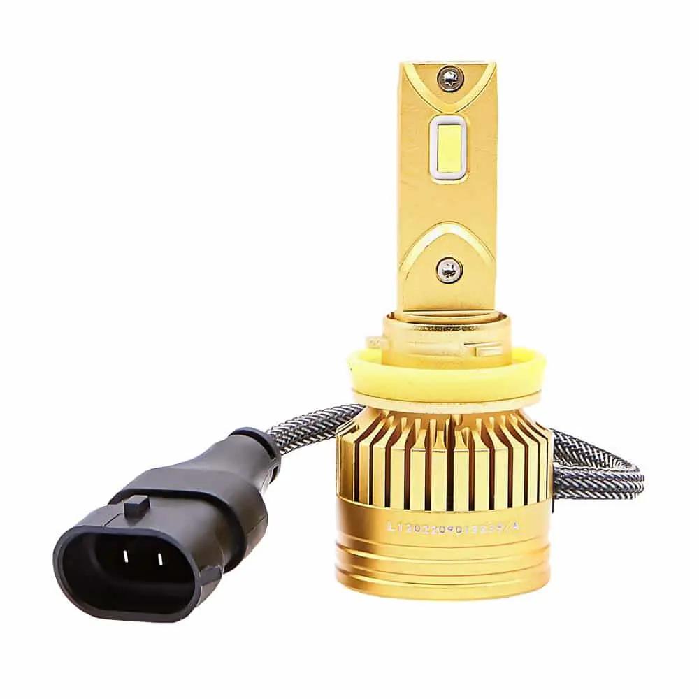 Gold-colored LED bulb with a finned round base, yellow collar and braided lead to a black two-pin plug