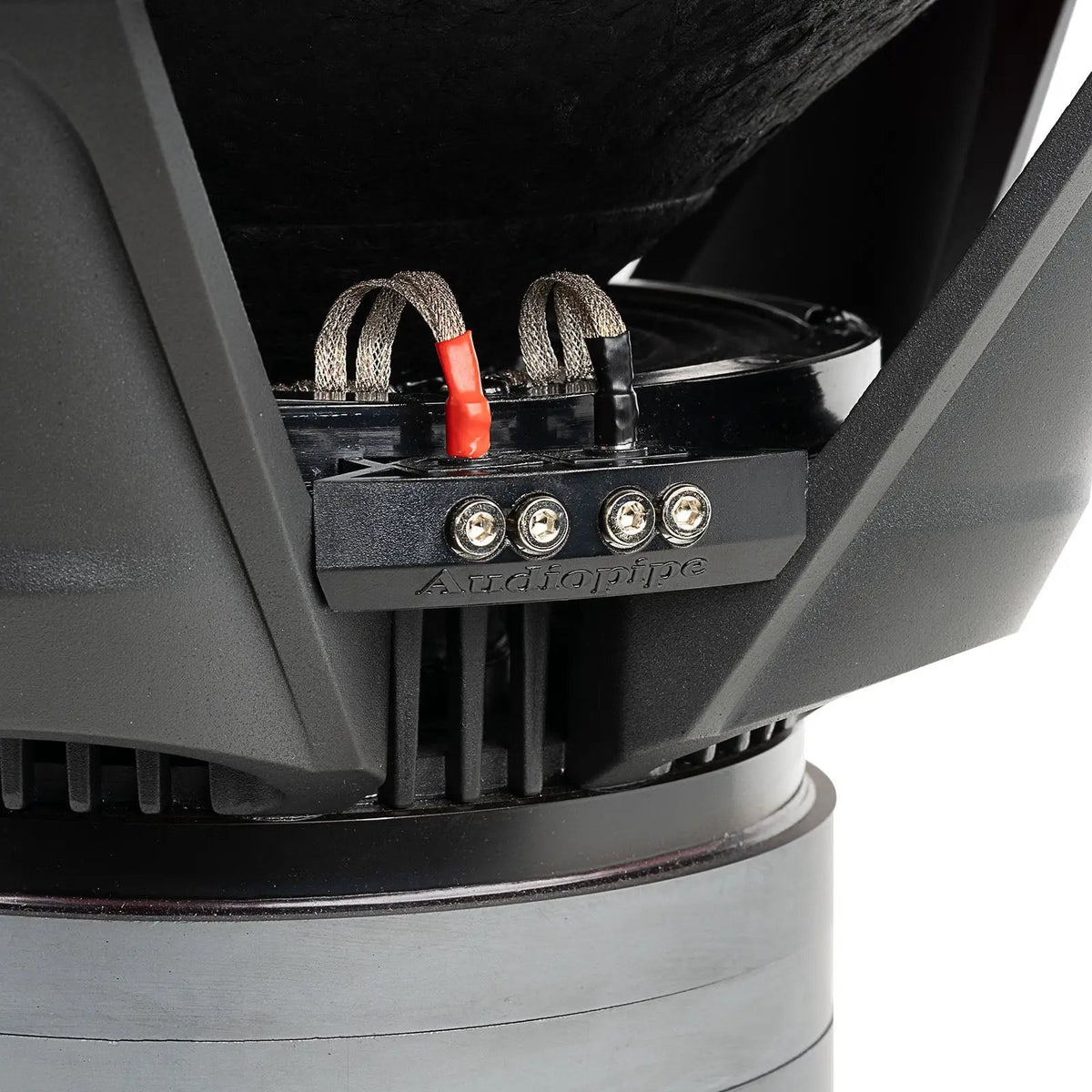Close-up of an Audiopipe subwoofer terminal block with four screw connections and red and black braided leads