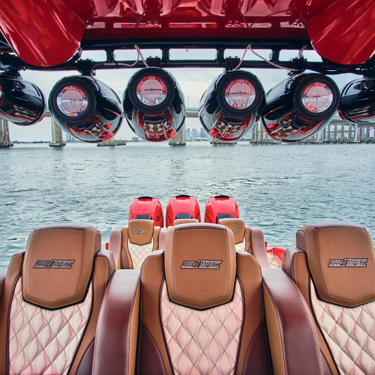Marine tower speakers mounted overhead above the upholstered seating in a boat