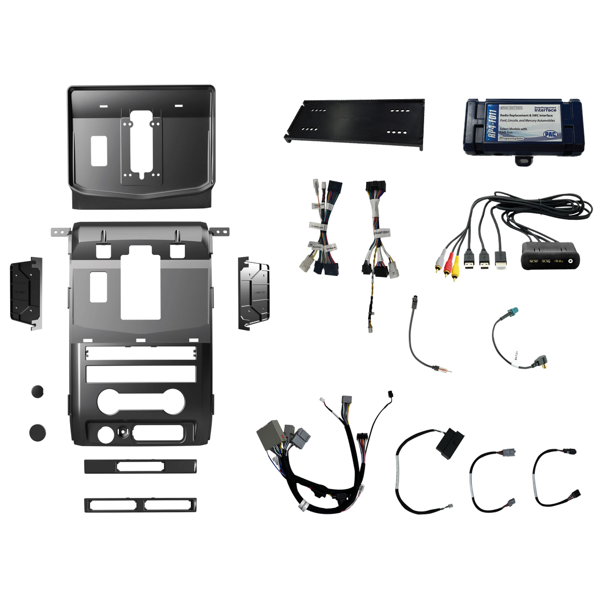 Radio installation components laid out with dashboard panels, mounting brackets, interface modules, wiring harnesses and adapter leads