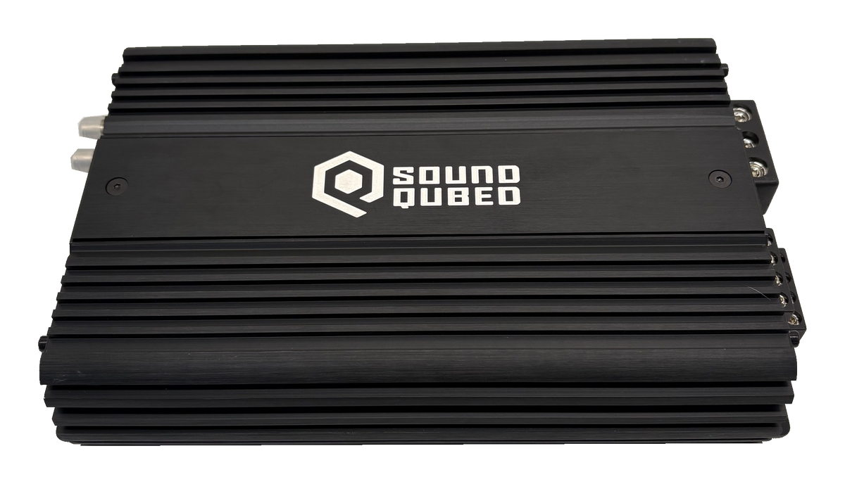 Top view of a black SoundQubed amplifier with a large white logo between rows of cooling fins