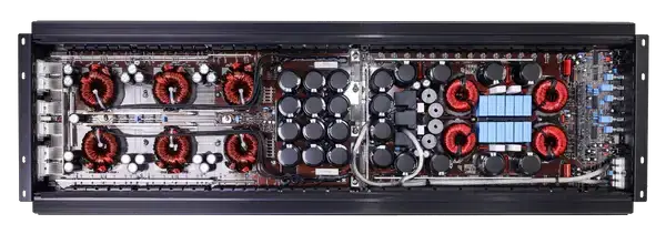 Inside a VFL Audio COMP 12K amplifier, showing its circuit board, copper coils and rows of capacitors.