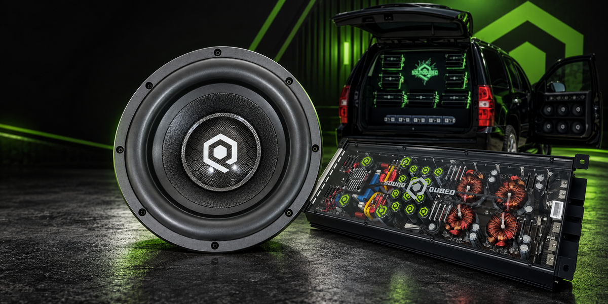 SoundQubed subwoofer and amplifier product flat lay on dark surface representing 12 Volt Outlet nationwide distributor spotlight for SoundQubed car audio