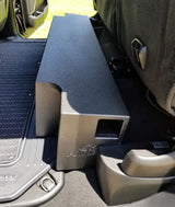 Fox Box Ram enclosure fitted under a raised rear seat, showing the side port beside the door sill