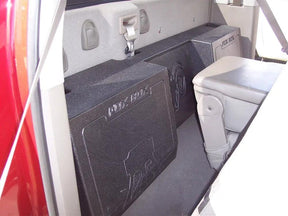Black Fox Box enclosure positioned behind a seat, with its embossed logo and central recessed section visible