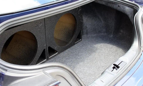 Two unloaded Fox Box enclosures positioned side by side in a carpeted vehicle trunk