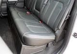 Truck rear bench seat lowered over a black under-seat subwoofer enclosure