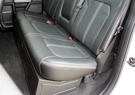 Truck rear bench seat lowered over a black under-seat subwoofer enclosure