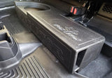 Black ported subwoofer enclosure installed beneath a raised rear seat