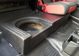 Close-up of the single speaker opening in a Fox Box Gladiator enclosure beneath a raised red-and-black rear seat