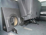 Empty subwoofer enclosure positioned behind folded-forward rear seats