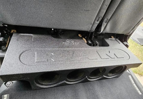 Four-opening subwoofer enclosure with RAM lettering shown beneath a raised rear seat