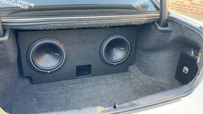 Dual-subwoofer enclosure installed in a car trunk