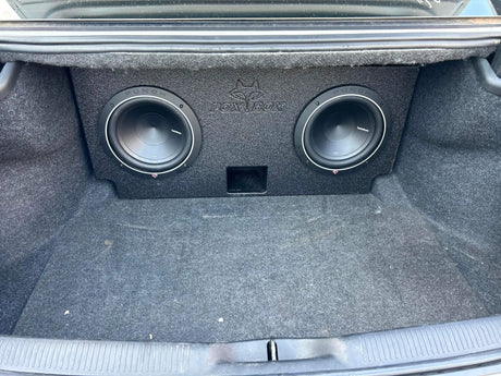Fox Box enclosure with two installed subwoofers and a center port positioned in a carpeted trunk
