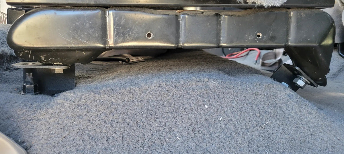 Close-up of a seat frame raised above the carpet on black spacer blocks