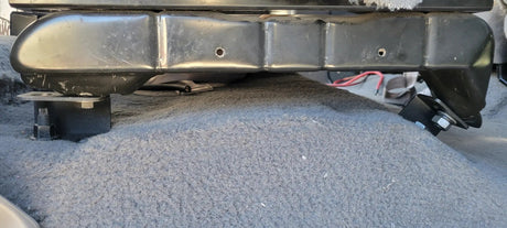 Close-up of a seat frame raised above the carpet on black spacer blocks