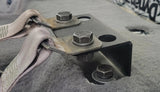Close-up of installed seat-lift brackets and bolts securing the seat-belt anchors
