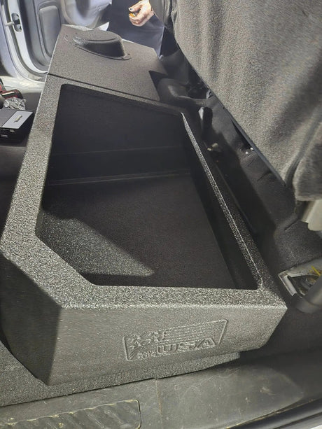 Installed FOX BOX enclosure viewed along its open storage tray beneath a raised rear seat