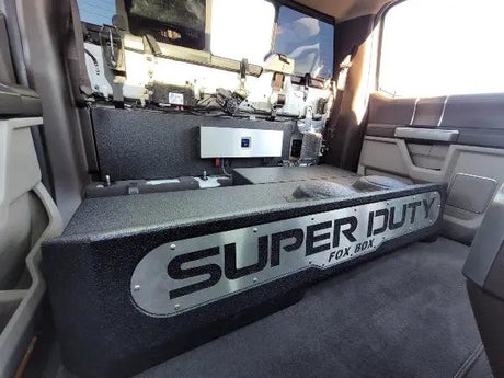 Fox Box enclosure installed behind a raised truck rear seat, with a silver SUPER DUTY front panel