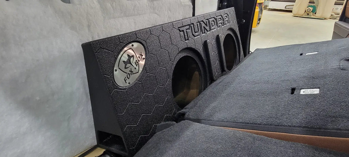 Fox Box TUNDRA enclosure with two empty speaker openings positioned behind folded-forward rear seats