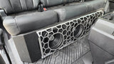 Fox Box Ford triple-subwoofer installation under the rear seat, with a honeycomb-pattern grille covering the speaker cones