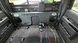 Fox Box triple-subwoofer enclosure mounted against the rear wall of a Ford Super Duty cab with the rear seat removed