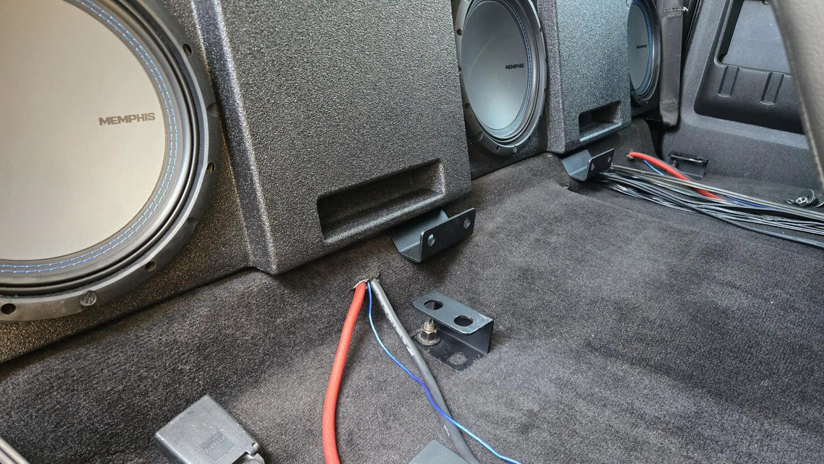 Installation example showing three Memphis subwoofers in a ported enclosure behind the rear seating area