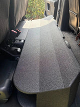 Black subwoofer enclosure fitted beneath the raised rear seat cushions