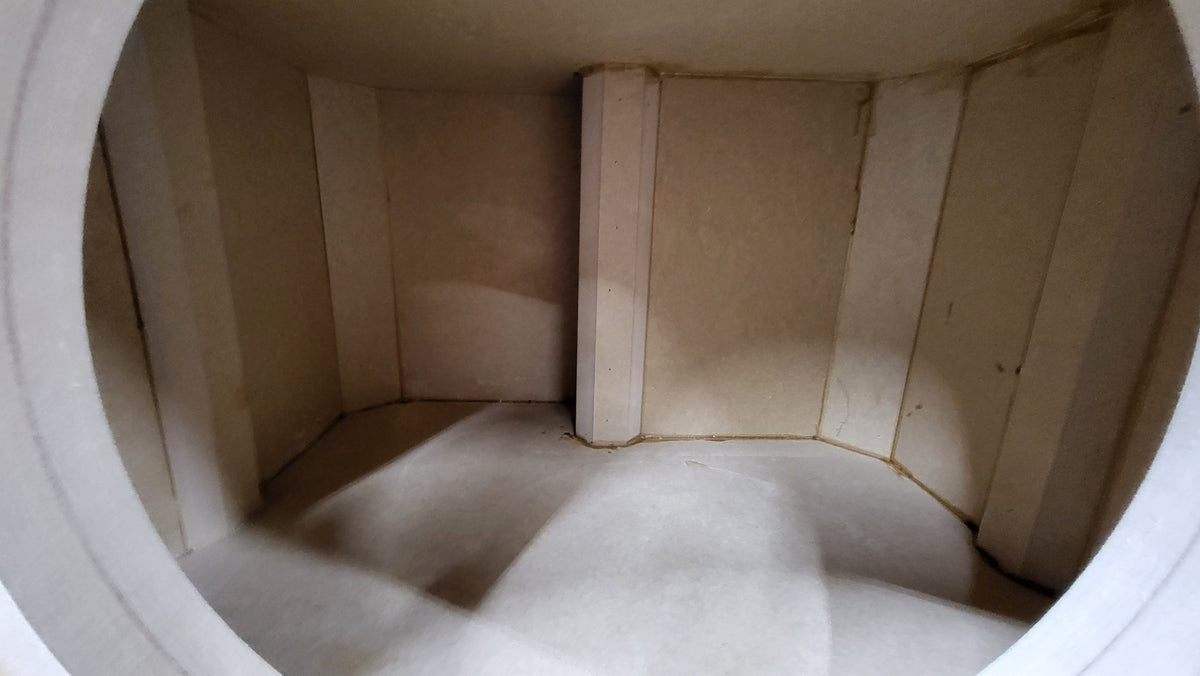 View through a speaker cutout showing the enclosure's internal bracing and joints