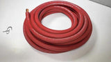 Coil of red power wire with an exposed conductor end on a white tabletop