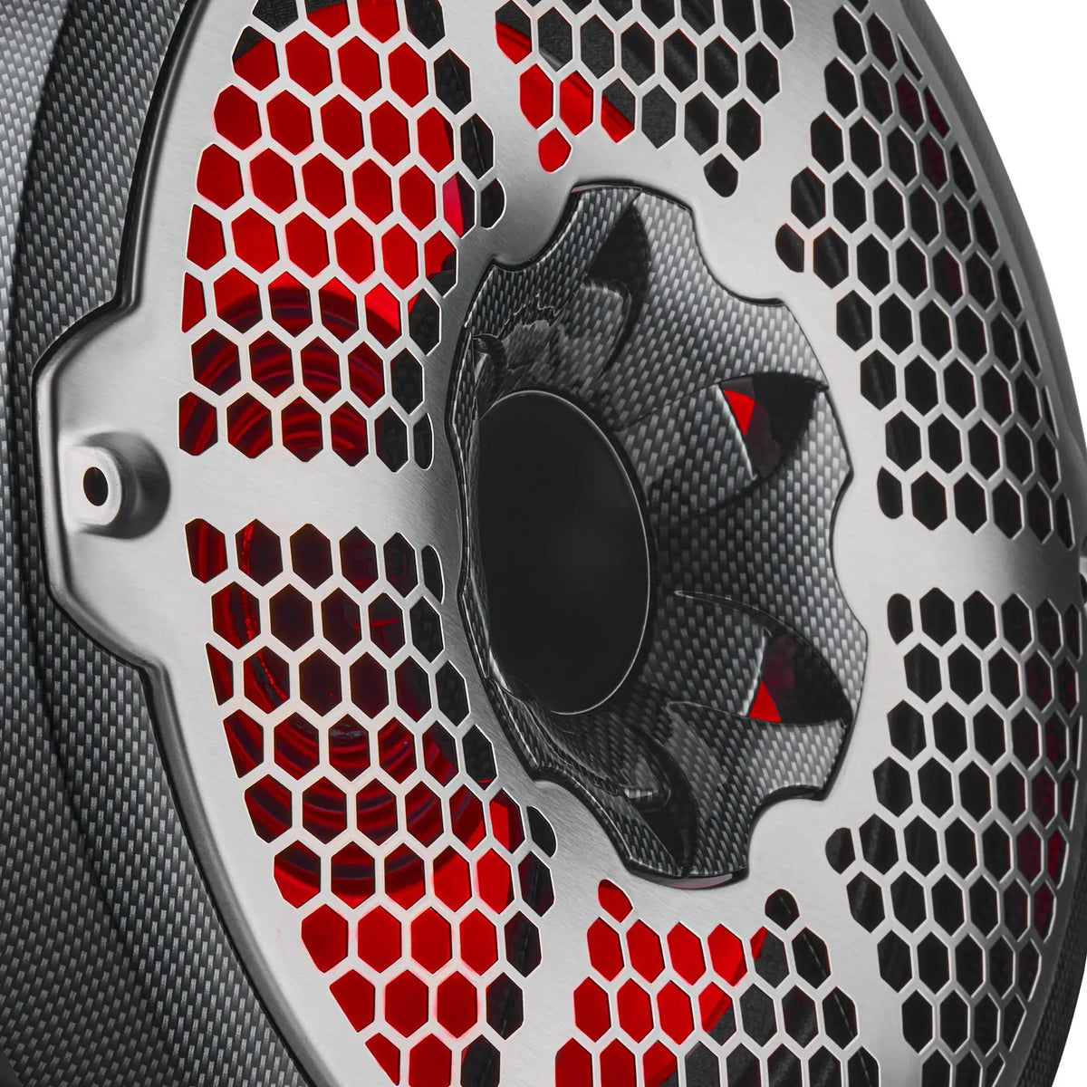 Close-up of a carbon-fiber-pattern DS18 speaker's honeycomb grille and central tweeter with red illumination