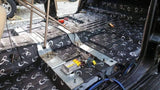 GP sound-deadening sheets fitted around the center tunnel and floor of a stripped vehicle cabin
