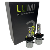 Two LUMI Stage 2 5202 LED Headlight Bulbs from Lumi are shown in front of a black box labeled â€œLUMI LED Headlight Systems Stage II Smart Kitâ€ on a plain background, delivering powerful 6000K illumination.