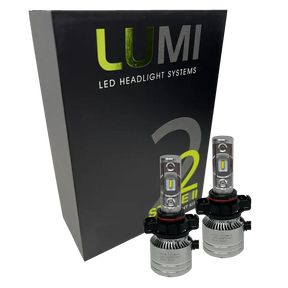 Two LUMI Stage 2 5202 LED Headlight Bulbs from Lumi are shown in front of a black box labeled â€œLUMI LED Headlight Systems Stage II Smart Kitâ€ on a plain background, delivering powerful 6000K illumination.