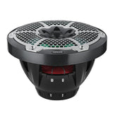 Low-angle view of a carbon-fiber-pattern DS18 speaker showing green-lit grille, red suspension and deep basket