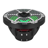 Low-angle view of a black DS18 speaker showing green-lit honeycomb grille, red suspension and deep basket