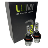 Two LUMI Stage 2 9004 LED Headlight Bulbs by Lumi are displayed in front of a black box labeled â€œLUMI LED Headlight Systems 2.â€ The bulbs have a metallic finish with prominent yellow CSP chips, delivering bright 6000K light for enhanced visibility.