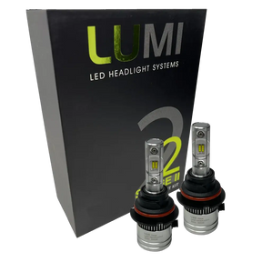 Two LUMI Stage 2 9004 LED Headlight Bulbs by Lumi are displayed in front of a black box labeled â€œLUMI LED Headlight Systems 2.â€ The bulbs have a metallic finish with prominent yellow CSP chips, delivering bright 6000K light for enhanced visibility.