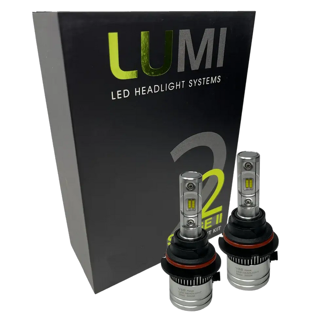 Two LUMI Stage 2 9004 LED Headlight Bulbs by Lumi are displayed in front of a black box labeled â€œLUMI LED Headlight Systems 2.â€ The bulbs have a metallic finish with prominent yellow CSP chips, delivering bright 6000K light for enhanced visibility.