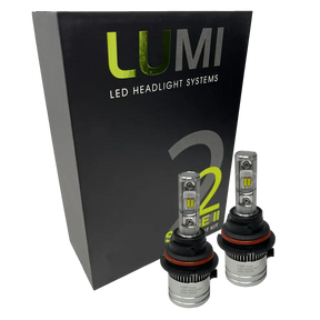 Two LUMI Stage 2 9006 LED Headlight Bulbs by Lumi, featuring advanced CSP chips and metallic bases with visible LED elements, are displayed in front of a black box labeled â€œLUMI LED Headlight Systems 2 Series II.â€ These bulbs deliver a crisp 6000K white light.