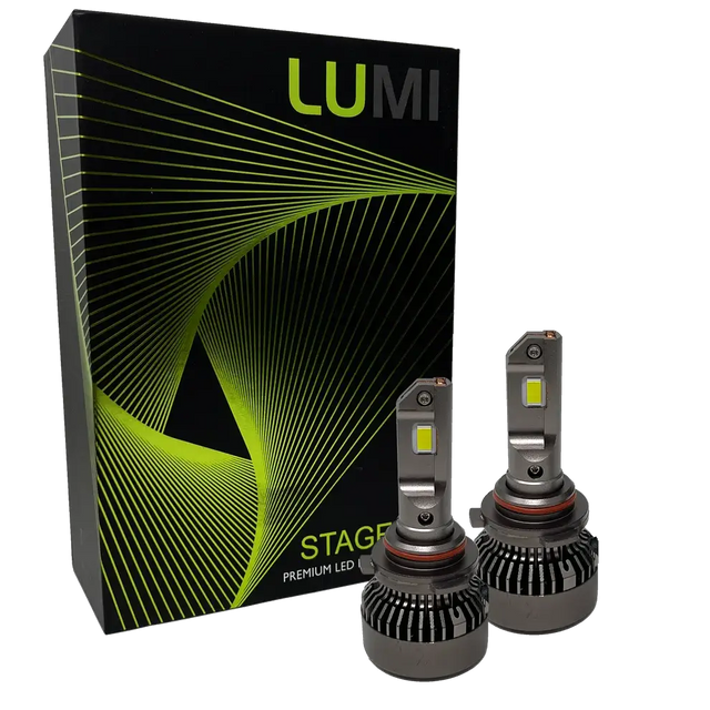 Two LUMI Stage 3 9006 LED headlight bulbs with heatsinks are displayed in front of a black Lumi box adorned with green and yellow curved line graphics, highlighting premium LED headlights that feature advanced CSP chips and a bright 6000K color temperature.