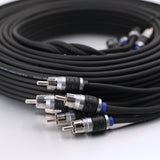 A coiled black audio cable with multiple RCA connectors in the foreground, photographed on a clean white surface.